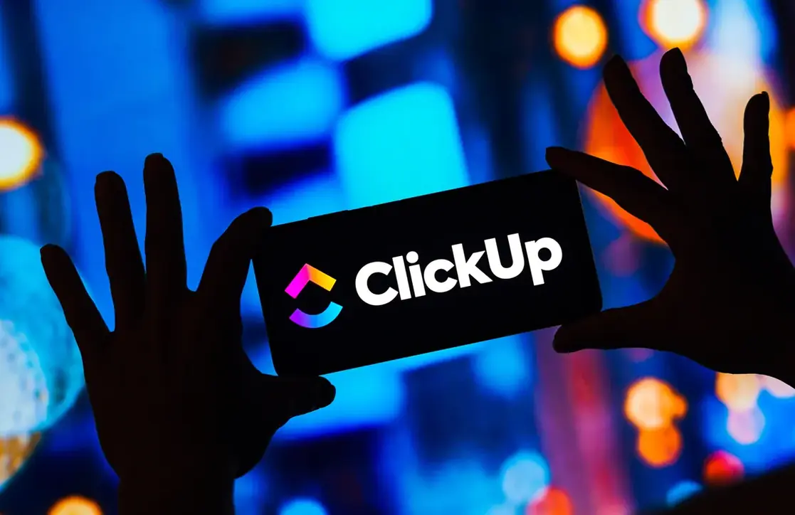 O logotipo do ClickUp aceso sobre fundo de luzes desfocadas